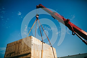 Crane lifts heavy container on a truck