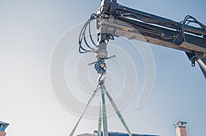 Crane lifts materials on the roof for construction and decoration of building.