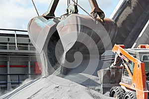 Crane loading cargo ship with gravel