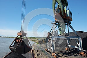 Crane loading coal to ship at Kolyma river port