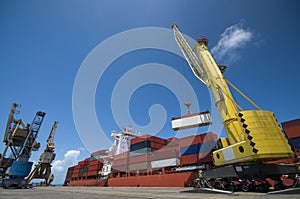 Crane lowering container to stack of containers.