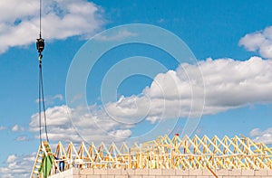 Crane moving roof trusses, into place with a contractor guiding the placement