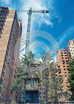 Crane near new high-rise building around the old dovecote