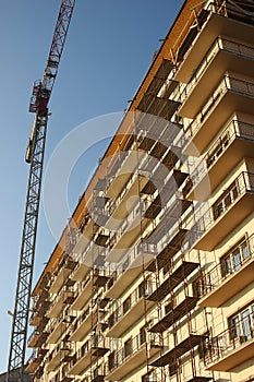 Crane next to building covered in scaffolds