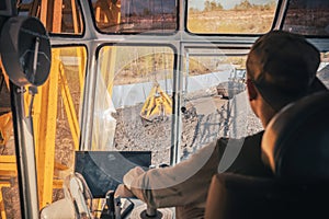 A crane operator controls heavy machinery at a coal loading dock located by the river,