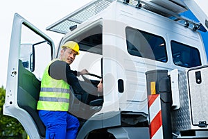 Crane operator driving with truck of construction site photo