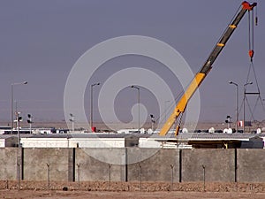 Crane place trailers behind blast barriers on a FOB in Basra photo