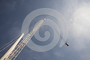 Crane and pole of windmill, against blue sunny sky