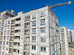 A crane is positioned on the roof of a high-rise building, symbolizing ongoing construction work in an urban setting