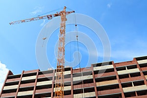 Crane and red brick residential building under construction