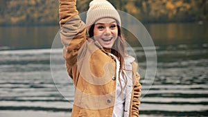 CRANE SHOT Beautiful Caucasian female women girl standing near beautiful lake in mountains and wave his hands. aslow mo