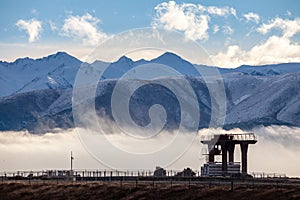 Crane silhouetted by Mountains. Contrast of nature and industry