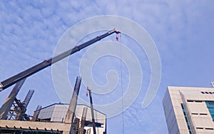 A crane towing in building site, with blue sky