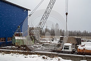 Crane and trucks on granite processing plant