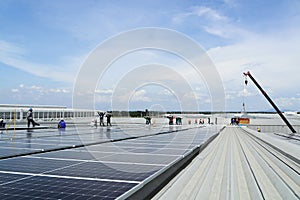 Crane Uploading Solar Panels on Roof with Installation Workers photo