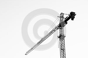 A crane at work on a building site in the city, against sky.