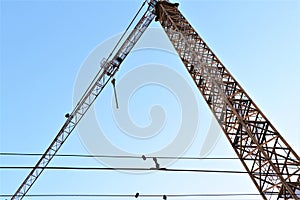 A crane at work on a building site in the city, against sky.