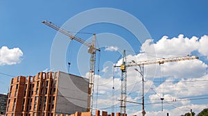 Crane and workers at construction site against blue sky