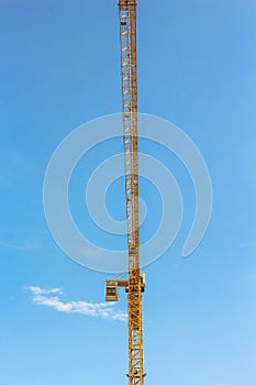 Crane and workers at construction site against blue sky