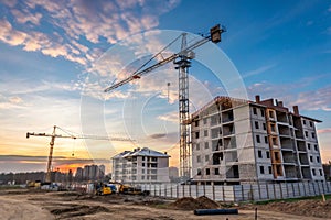 Crane working on construction site at sunset