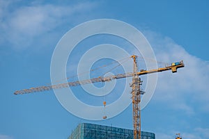 crane is working under the blue sky, for skyscraper construction