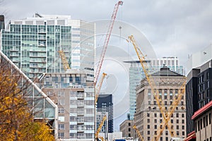 Cranes and building device on a construction site of a skyscraper in downtown Montreal, surrounded by other high rise towers