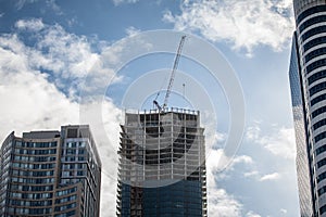 Cranes and building devices on a construction site of a skyscraper in downtown Toronto, surrounded by other high rise towers