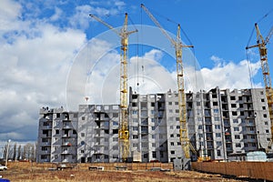 Cranes are building new residential district. Apartment building construction cranes on the construction site