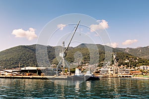 Cranes at cargo terminal in Kotor bay. Montenegro docking station with cranes and tug boats.