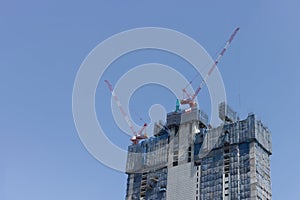 Cranes on a construction site against blue sky