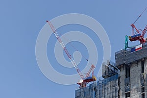 Cranes on a construction site against blue sky