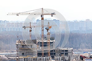 Cranes on construction site build high-rise building
