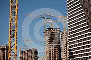 Cranes and construction site. Construction of apartment buildings