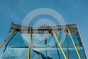 Cranes on glass facade office building under construction