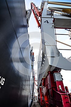 Cranes for handling containers on the docks next to a container ship