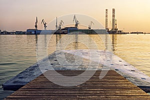 Cranes on harbour at sunset