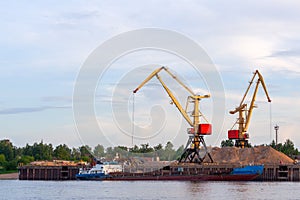 Cranes operate in river port.