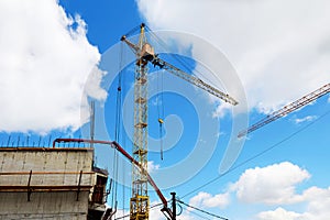 Cranes and other equipment on the construction site against the blue sky. Construction of the building.