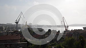 Cranes in shipyard at sunset. Harbour in Adriatic sea. Jackup rig, Oil platform and Container crane in Dockyard. Ship port. Indust