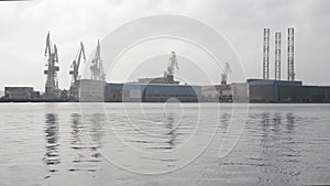 Cranes in shipyard at sunset. Harbour in Adriatic sea. Jackup rig, Oil platform and Container crane in Dockyard. Ship port. Indust