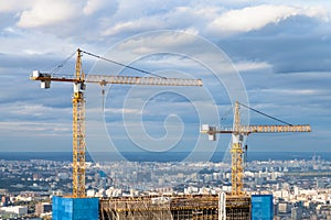 Cranes at top of skyscraper under construction