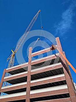 Cranes and workers erect building. Teamwork and Construction