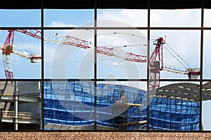 Cranes and yard reflected in glass window