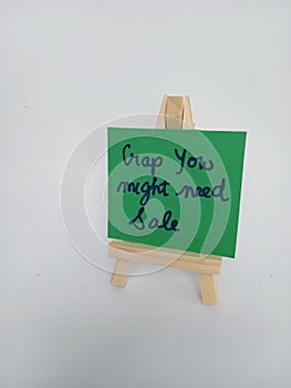 Crap you might need sale sign on a wood easel on a white background