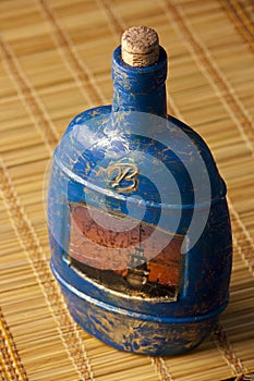 Craquelure decoupage bottle on a mat photo