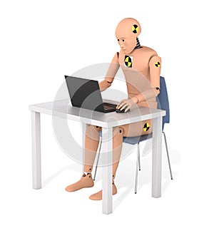 Crash Test Dummy Sitting at a Table Using Laptop