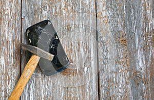 Crashed black smartphone is lying on the old wooden background. Broken lcd touch screen with a hammer. Information technology