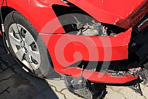 Crashed car of red color. Side view of the wrecked vehicle. The car crash. Traffic accident