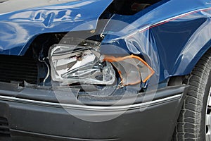 Crashed Headlight on Blue Car photo