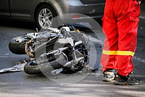 Crashed motorcycle after road accident with a car